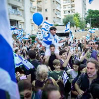 A crowd cheers as freed hostage Evyatar David arrives at his home in Kfar Saba, October 26, 2025. (Erik Marmor/Flash90)
