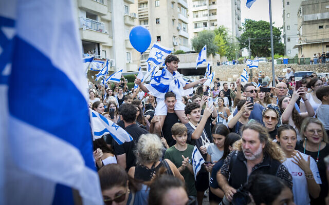 A crowd cheers as freed hostage Evyatar David arrives at his home in Kfar Saba, October 26, 2025. (Erik Marmor/Flash90)