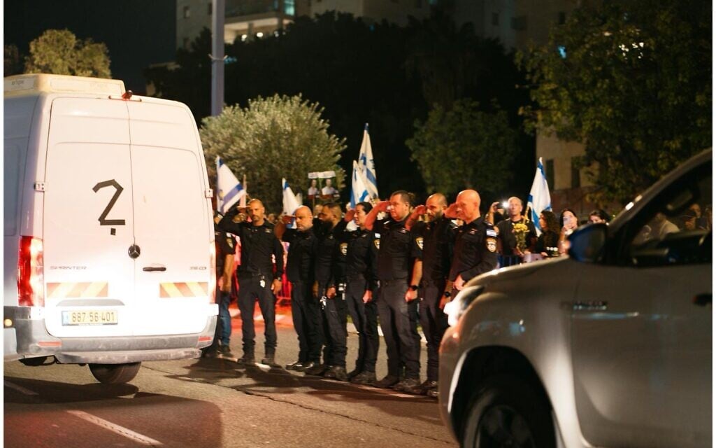 Police salute a van carrying the remains of four hostages as they are being taken for identification on October 13, 2025 (Israel Police)