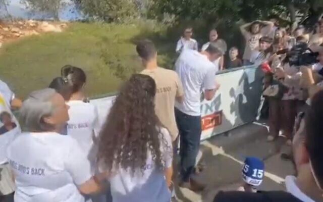 Taking down the 'Bring Alon Ohel home' banner in his hometown on October 13, 2025. (Courtesy)