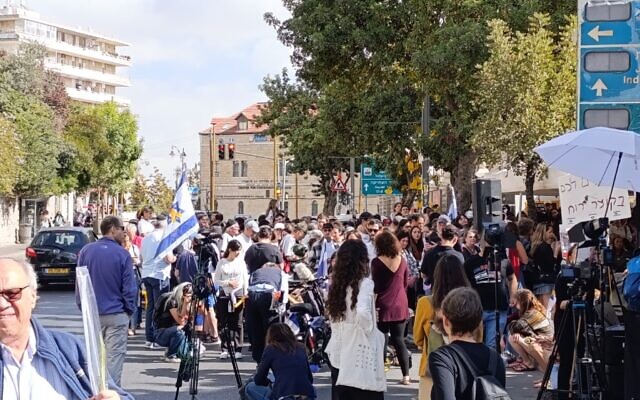 A crowd gathers at the hostage families' protest tent on Balfour Street in Jerusalem to watch the release of hostages from Gaza, October 13, 2025. (Zev Stub/Times of Israel)