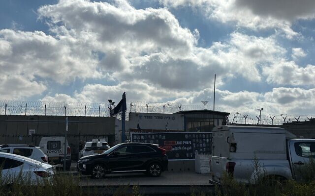 A banner hung outside Ofer Prison in the West Bank ahead of the release of Palestinian prisoners that reads: "He who threatens a flood is drowned and wiped out," seen on October 13, 2025. (Charlie Summers/Times of Israel)