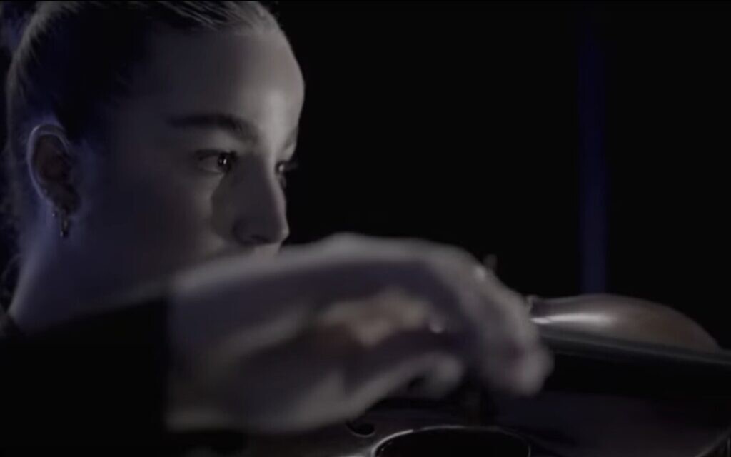 Released hostage Agam Berger plays at the Bereaved Families Memorial Ceremony marking two years since the October 7, 2023, massacre, in Tel Aviv's Yarkon Park, on October 7, 2025. (Screenshot)