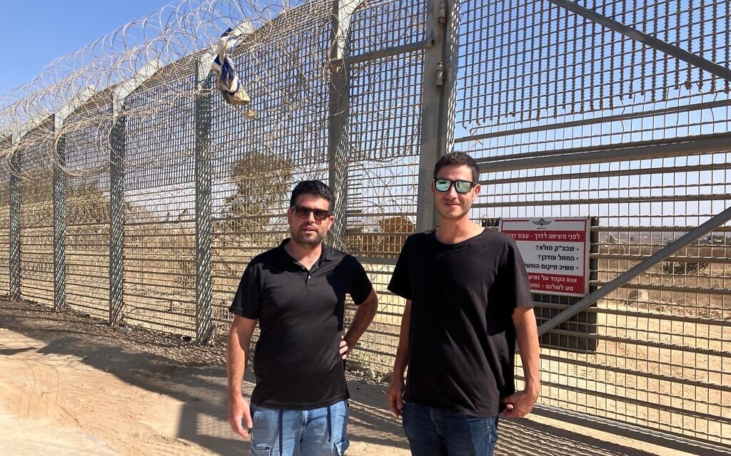 Kibbutz El-Rom emergency response team members Shimon Michael, right, and Gal Fitusi stand at the border fence near the Syrian village of al-Hamidiya on October 23, 2025. (Diana Bletter/Times of Israel)
