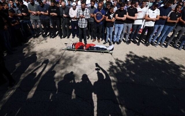 Mourners pray over the body of 15-year-old Palestinian Yamen Hamed who was killed by Israeli forces, during his funeral in Silwad, near the city of Ramallah in West Bank on October 31, 2025. (JAAFAR ASHTIYEH / AFP)