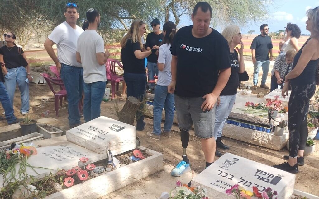 Aviad Behar stands next to the graves of his wife Dana and son Carmel on October 6, 2025. (Kibbutz Be'eri)