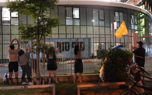 Volunteers hang up a poster welcoming back the hostages as they await their release from Hamas captivity, on October 12, 2025. (Lior Segev/Pro-Democracy Protest Movement)