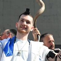 Released hostage Bar Kuperstein wears tefillin at a prayer event at Hostages Square in Tel Aviv on October 31, 2025. (Paulina Patimer/Hostages Forum)