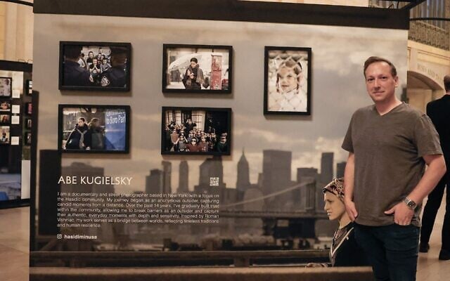 Abe Kugielsky poses in front of his installation Humans of New York’s 'Dear New York' exhibition in Grand Central’s Vanderbilt Hall, running from October 6 to October 19, 2025. (Courtesy Abe Kugielsky via JTA)