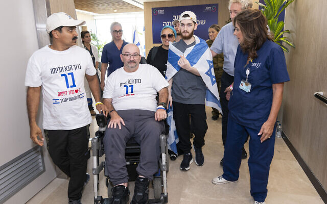 Former hostage Bar Kuperstein reunites with his father Tal (second from L) in the hospital following his release from captivity on October 13, 2025. (GPO)