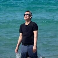 Omri Miran pictured at the beach, with his wife Lishay and two daughters out of shot, on October 17, 2025, soon after his discharge from the hospital, and four days after he was released from more than two years in Hamas captivity in Gaza. (Via X; Eli Teichman and Shir Katz)