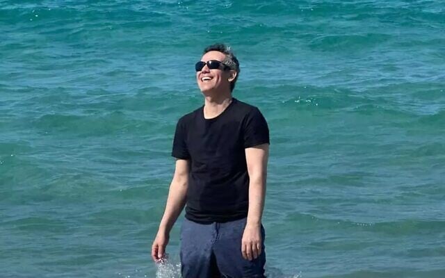 Omri Miran pictured at the beach, with his wife Lishay and two daughters out of shot, on October 17, 2025, soon after his discharge from the hospital, and four days after he was released from more than two years in Hamas captivity in Gaza. (Via X; Eli Teichman and Shir Katz)