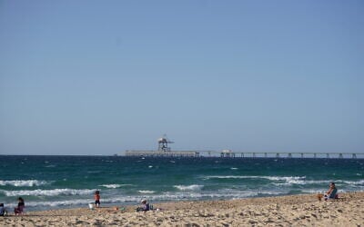 Beachgoers pass time at Zikim Beach in southern Israel, the site of a massacre during Hamas's October 7, 2023, days after reopening to visitors, on October 21, 2025. (Charlie Summers/Times of Israel)