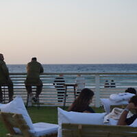 Beachgoers pass time on Zikim Beach in southern Israel, the site of a massacre during Hamas's October 7, 2023, days after reopening to visitors, on October 21, 2025. (Charlie Summers/Times of Israel)