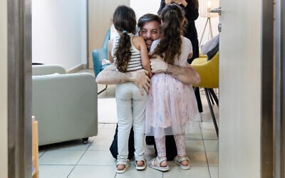 Freed hostage David Cunio reunites with his twin daughters Emma and Yuli, both also former hostages freed in November 2023, at Sheba Medical Center, October 13, 2025. (Shauli Lendner/GPO)