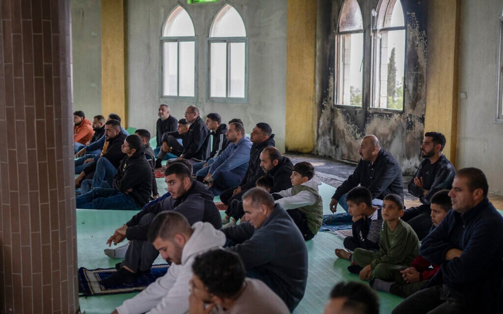 Palestinians attend Friday prayers at Al-Hajj Hamida Mosque in the West Bank town of Deir Istiya on November 14, 2025, one day after it was set on fire by Israeli settlers. (Ilia Yefimovich/dpa via Reuters Connect)