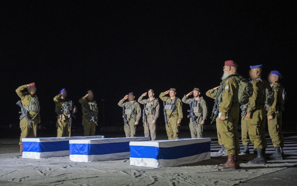 IDF commanders, including Southern Command chief Maj. Gen. Yaniv Asor, Gaza Division commander Brig. Gen. Barak Hiram, Givati Brigade commander Col. Netanel Shamaka, and 7th Armored Brigade Commander Col. Shaul Israeli, salute over the caskets containing the bodies of Col. Asaf Hamami, Cpt. Omer Neutra, and Staff Sgt. Oz Daniel, during a short ceremony led by IDF Chief Rabbi Brig. Gen. Eyal Krim in the Gaza Strip, late November 2, 2025. (Israel Defense Forces)