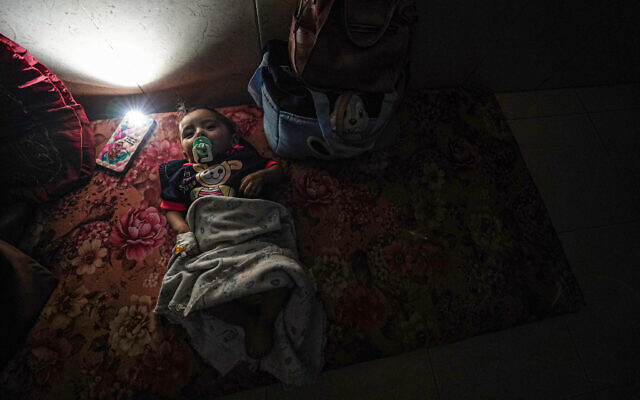 Illustrative: A telephone with a flashlight is a placed next to a baby lying on a mattress on the floor, after a partial power cut at the Al-Aqsa Martyrs Hospital in Deir al-Balah on May 23, 2024. (Bashar TALEB / AFP) Illustrative: A telephone with a flashlight is a placed next to a baby lying on a mattress on the floor, after a partial power cut at the Al-Aqsa Martyrs Hospital in Deir al-Balah on May 23, 2024. (Bashar TALEB / AFP)