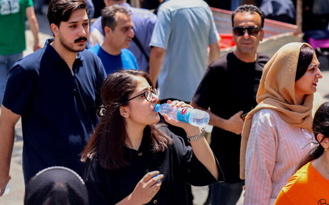 An Iranian girl drinks water during a heatwave in the capital Tehran on August 9, 2025. (ATTA KENARE / AFP)