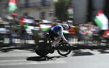 Protesters wave Palestinian flags as Team Israel Premier Tech's British cyclist Jake Stewart competes during the 18th stage of the Vuelta a Espana, a race against the clock between Valladolid and Valladolid in Spain, on September 11, 2025. (Miguel RIOPA / AFP)