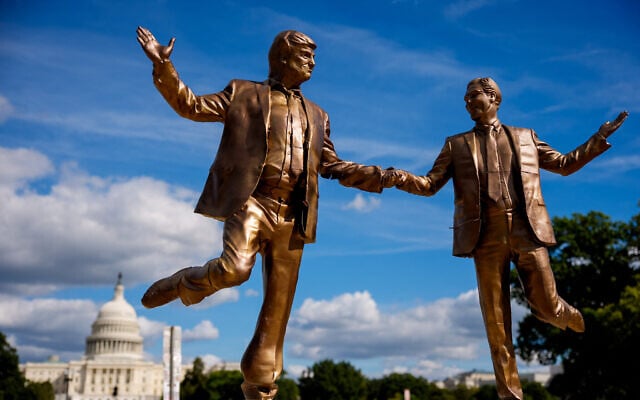 The Dome of the US Capitol Building is visible behind a statue depicting US President Donald Trump and Jeffrey Epstein holding hands on the National Mall on October 2, 2025 in Washington, DC. (Andrew Harni / Getty Images via AFP)