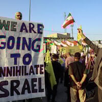 An Iranian man holds an anti-Israeli placard during a ceremony to mark the first anniversary of the death of Hezbollah leader Hassan Nasrallah, in Tehran, on October 2, 2025 (AFP)