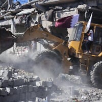 A bulldozer deployed by the Gaza Municipality clears building rubble from streets in Gaza City, October 14, 2025. (AFP)