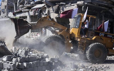 A bulldozer deployed by the Gaza Municipality clears building rubble from streets in Gaza City, October 14, 2025. (AFP)