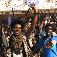 This image grab taken from handout video footage released on Sudan's paramilitary Rapid Support Forces (RSF) Telegram account on October 26, 2025, shows RSF fighters holding weapons and celebrating in the streets of El-Fasher in Sudan's Darfur (Rapid Support Forces (RSF) / AFP)