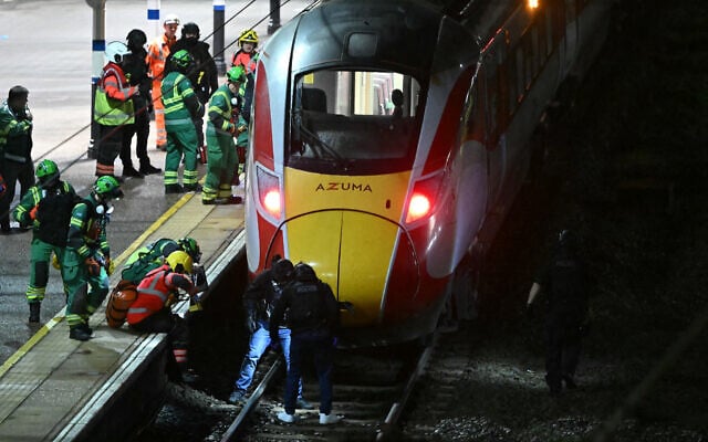 UK police officers and members of emergency services search the track beneath an LNER Azuma train at Huntingdon Station in Huntingdon, eastern England, on November 1, 2025, following a stabbing on a train. (Photo by JUSTIN TALLIS / AFP) UK police officers and members of emergency services search the track beneath an LNER Azuma train at Huntingdon Station in Huntingdon, eastern England, on November 1, 2025, following a stabbing on a train. (Photo by JUSTIN TALLIS / AFP)