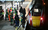 Police officers and members of the emergency services work alongside an LNER Azuma train at Huntingdon Station in Huntingdon, eastern England, on November 1, 2025, following a stabbing on a train. (JUSTIN TALLIS / AFP)