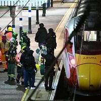 Police officers and members of the emergency services work alongside an LNER Azuma train at Huntingdon Station in Huntingdon, eastern England, on November 1, 2025, following a stabbing on a train. (JUSTIN TALLIS / AFP)