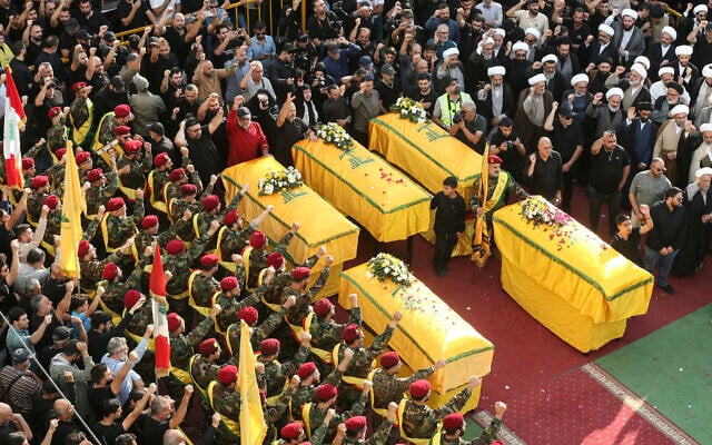 Hezbollah supporters gather around the coffins of five operatives killed in recent Israeli strikes during their funeral in southern Lebanese city of Nabatieh, November 2, 2025. (MAHMOUD ZAYYAT / AFP)