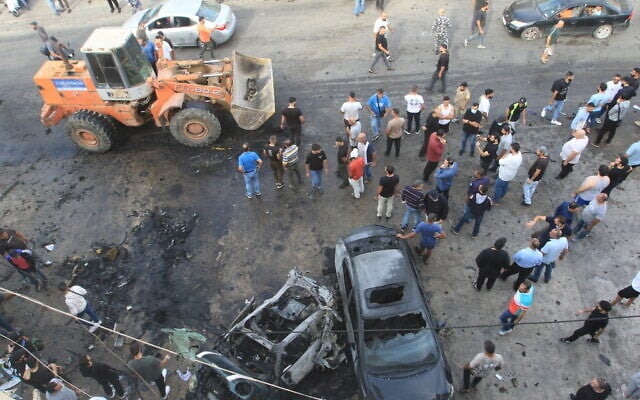 People gather at the site of an Israeli drone strike that targeted a vehicle in the southern Lebanese village of Doueir near the city of Nabatiyeh, on November 3, 2025. (Mahmoud ZAYYAT / AFP)