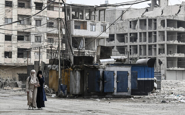 Syrian women walk past a privately owned electricity generator in the Ain Tarma area, on the eastern outskirts of the capital Damascus, on November 4, 2025. (LOUAI BESHARA / AFP) Syrian women walk past a privately owned electricity generator in the Ain Tarma area, on the eastern outskirts of the capital Damascus, on November 4, 2025. (LOUAI BESHARA / AFP)