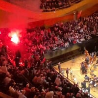 A screenshot taken from a UGC video shows incidents in the Pierre-Boulez Hall of the Philharmonie de Paris, where a person ignited a smoke bomb during a concert by the Israel Philharmonic Orchestra on November 6, 2025. (Jean-Michel TRANSON / AFPTV / AFP)