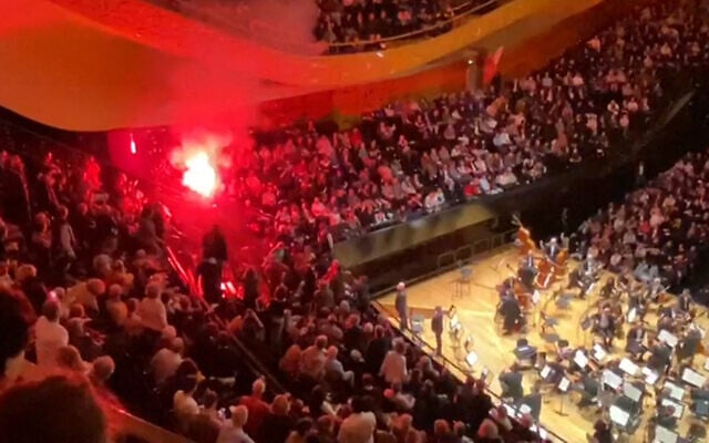 A screenshot taken from a UGC video shows incidents in the Pierre-Boulez Hall of the Philharmonie de Paris, where a person ignited a smoke bomb during a concert by the Israel Philharmonic Orchestra on November 6, 2025. (Jean-Michel TRANSON / AFPTV / AFP)