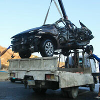 Workers remove the wreckage of a car targeted by an Israeli drone strike in the southern Lebanese village of Baissariyeh on November 10, 2025.  (Mahmoud Zayyat/AFP)