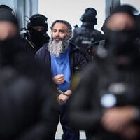 Saudi Arabian defendant Taleb Jawad al-Abdulmohsen (C) is led by judicial officers into the temporary courtroom in Magdeburg, eastern Germany on November 10, 2025, after a break of his trial over a deadly Christmas market attack in December 2024. (RONNY HARTMANN / AFP)