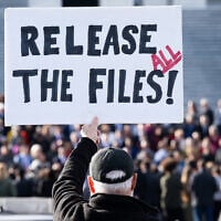 A protester holds a sign related to the release of the Jeffrey Epstein case files outside the US Capitol in Washington, DC, November 12, 2025 (SAUL LOEB / AFP)
