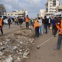 Palestinians clean the streets of Gaza City on November 15, 2025. (Omar AL-QATTAA / AFP)