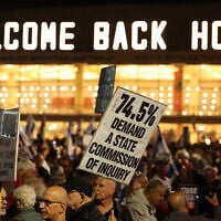 Israeli anti-government protesters lift up placards during a demonstration against the prime minister and in support of establishing a state commission of inquiry into Hamas's October 7, 2023, attacks on Israel, in Tel Aviv on November 15, 2025. (Jack GUEZ / AFP)