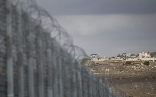 A photograph taken from Israel shows the border fence (L) separating northern Israel from southern Lebanon, with the Lebanese village of Maroun el Ras visible in the background on November 16, 2025 (Jalaa MAREY / AFP)