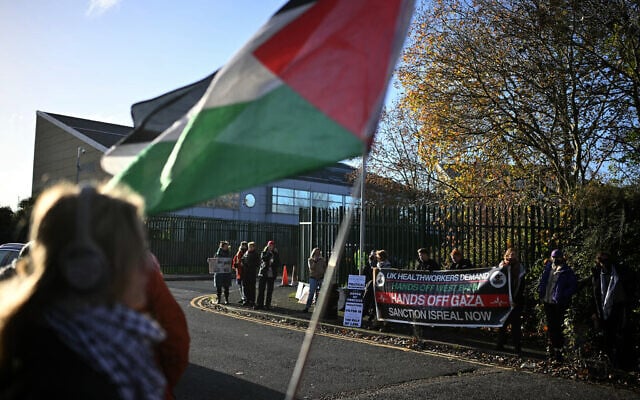 Supporters of alleged Palestine Action activists accused of breaking into Israeli-based defense firm Elbit Systems' site in Bristol in August 2024, hold placards and wave Palestinian flags outside Woolwich Crown Court in south east London on November 17, 2025, where the activists are due to stand trial. (Ben STANSALL / AFP)