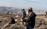 Illustrative: Israeli settlers clash with security forces in the West Bank on November 17, 2025. (Menahem KAHANA / AFP)