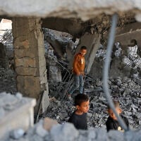 Illustrative: Palestinian boys walk amid the debris of a building in Gaza City's Zeitoun neighborhood following an Israeli airstrike, November 20, 2025. (Omar AL-QATTAA / AFP)