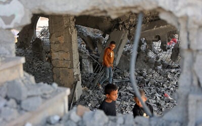 Illustrative: Palestinian boys walk amid the debris of a building in Gaza City's Zeitoun neighborhood following an Israeli airstrike, November 20, 2025. (Omar AL-QATTAA / AFP)