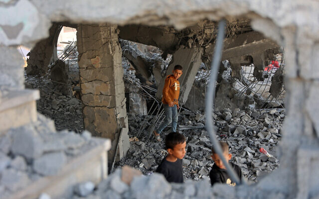Illustrative: Palestinian boys walk amid the debris of a building in Gaza City's Zeitoun neighborhood following an Israeli airstrike, November 20, 2025. (Omar AL-QATTAA / AFP) Illustrative: Palestinian boys walk amid the debris of a building in Gaza City's Zeitoun neighborhood following an Israeli airstrike, November 20, 2025. (Omar AL-QATTAA / AFP)