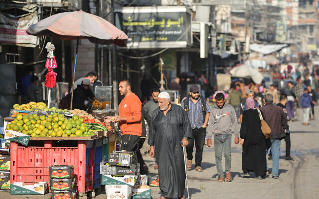 Palestinians walk through a market street in Deir al-Balah, in the central Gaza Strip, on November 20, 2025. (Eyad Baba / AFP) Palestinians walk through a market street in Deir al-Balah, in the central Gaza Strip, on November 20, 2025. (Eyad Baba / AFP)