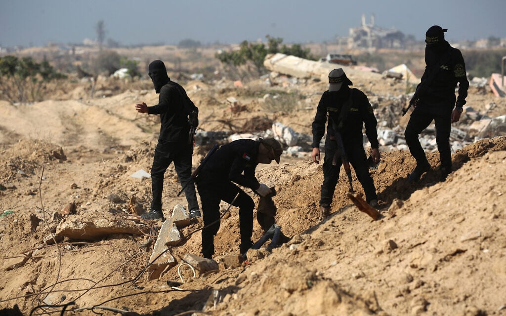Islamic Jihad terrorists appear to search for the bodies of hostages north of Nuseirat, Gaza Strip, November 21, 2025. (Eyad Baba / AFP) Islamic Jihad terrorists appear to search for the bodies of hostages north of Nuseirat, Gaza Strip, November 21, 2025. (Eyad Baba / AFP)